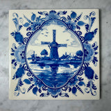 Delft blue tile with a windmill design on a marble surface