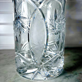 A close-up of Vintage Zawiercie Laurencie Cut Glass Tall Crystal Cracker Jar with geometric and floral etched patterns, resting on a marble surface.
