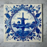 Delft blue tile with a windmill design on a marble surface