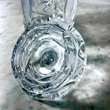 Inside of the lid of a Vintage Zawiercie Laurencie Cut Glass Tall Crystal Cracker Jar with jar standing behind it on a mottled gray surface.